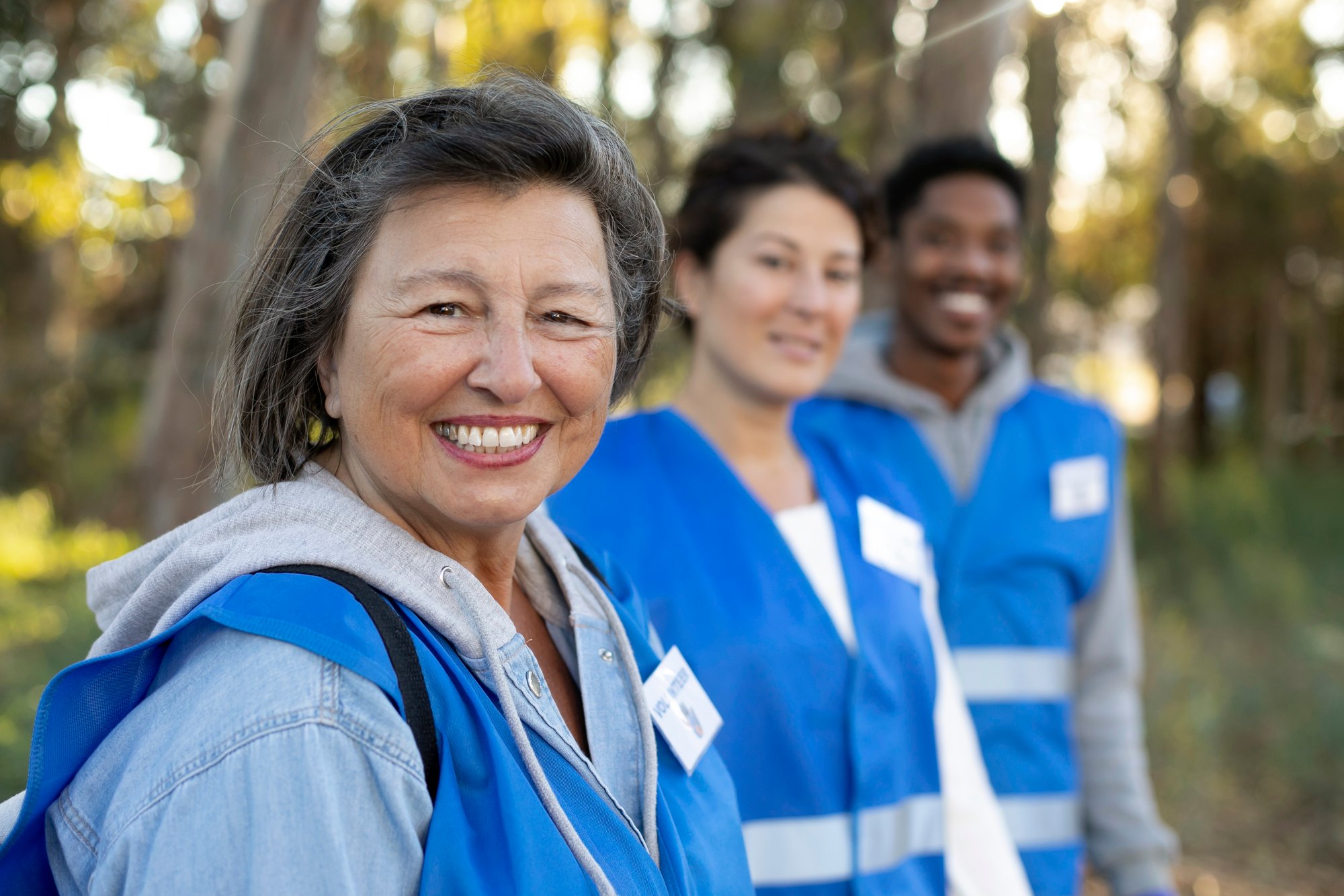 medium-shot-smiley-volunteers-outdoors Image by freepik